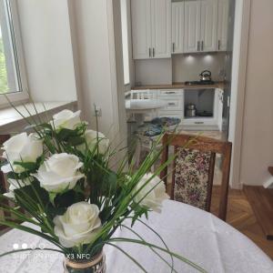 eine Vase voller weißer Rosen auf einem Tisch in der Unterkunft Атмосферная квартира в центре in Odessa