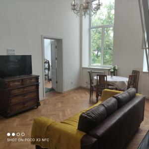 ein Wohnzimmer mit einem Sofa, einem TV und einem Tisch in der Unterkunft Атмосферная квартира в центре in Odessa