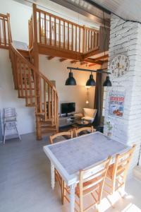 a dining room with a table and a staircase at Le Belvosgien in Gérardmer