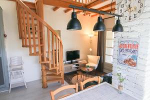 a living room with a staircase and a television at Le Belvosgien in Gérardmer