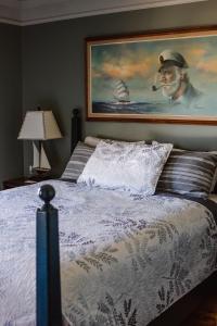 a bedroom with a bed and a painting on the wall at Auberge d'Anjou-Cocooning Café in Petit Rocher