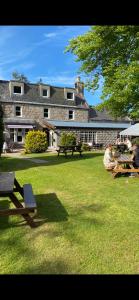 duży budynek z ludźmi siedzącymi w trawie w obiekcie Bennachie Lodge Hotel in Kemnay w mieście Inverurie