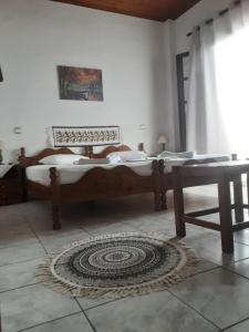 a bedroom with a bed and a table and a rug at Magda Studios - Double Bed Room N4 in Zagora