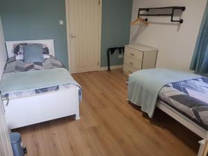 1 dormitorio con 2 camas individuales y vestidor en Skeabostview Brand New Self catering, en Skeabost