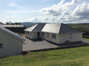 a large white house with a large driveway at Skeabostview Brand New Self catering in Skeabost