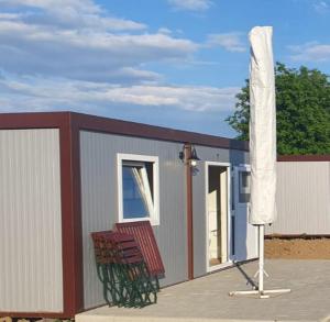 a small building with two chairs and an umbrella at GLAMTAINER COURT in Curteni +4 photos