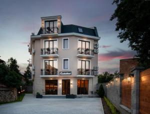 キュステンディルにあるFamily Hotel Konstantinoviの暗い屋根の白い大きな建物