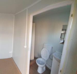 a small bathroom with a toilet and a sink at GLAMTAINER COURT in Curteni