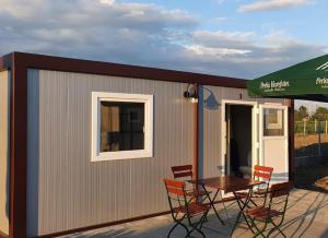 a small shed with a table and chairs on a patio at GLAMTAINER COURT in Curteni