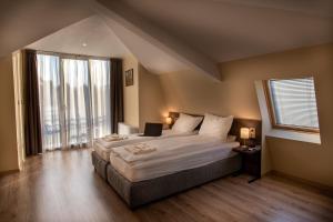 a bedroom with a large bed with a laptop on it at Семеен Хотел Константинови in Kyustendil