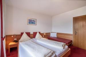 een hotelkamer met 2 bedden en een deur bij Hahnenkamm Rainegg in Schenna