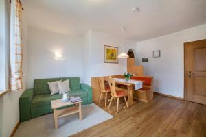 een woonkamer met een groene bank en een tafel bij Hahnenkamm Rainegg in Schenna