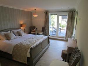 a bedroom with a large bed and a balcony at Willow Lodge Hambleton in Poulton le Fylde