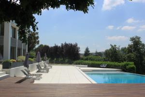 a swimming pool with lounge chairs next to a building at Quinta Milhão - Casa do Pomar in Guimarães