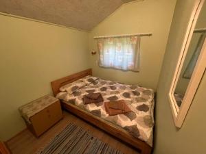 niewielka sypialnia z łóżkiem i oknem w obiekcie Metskonna Forest House w mieście Nõva