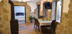 a dining room with a table and a fireplace at Family Wellness Jacuzzi Sauna Wood Fired Hot Tub 8 Min from Heviz in Rezi