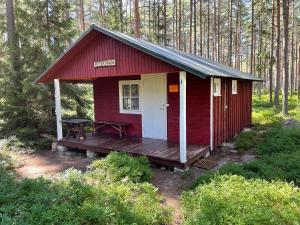 una cabina rossa con ponte in legno nel bosco di Metskonna Forest House a Nõva