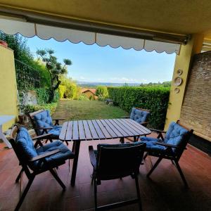 a wooden table and chairs on a patio with a view at Appartamento Stropea con giardino privato e piscina in Soiano del Lago +19 photos