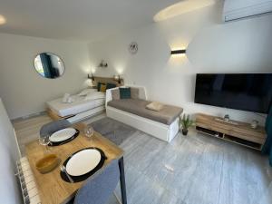 een woonkamer met een bank en een tafel bij Chaleureux studio, 200m de la plage, parking, wifi in Roquebrune-Cap-Martin