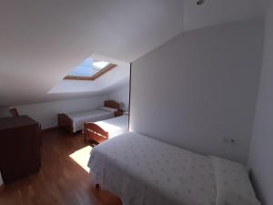 a small bedroom with a bed and a window at Ático La Plaza in Arriondas