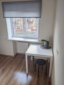 リエパーヤにあるNiedru apartamentiの窓のある部屋(白いテーブル、椅子付)