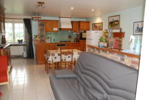 cocina y comedor con sofá en una habitación en Ti ar Rozenn, en Mont-Dol