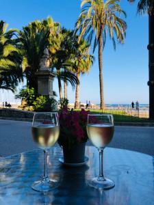 two glasses of wine sitting on a table near the beach at Fragata Beach Seaview in Sitges +28 photos