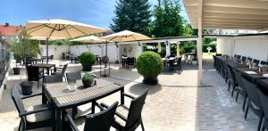 an outdoor patio with tables and chairs and umbrellas at Hotel Restaurant Alt Pirmasens in Pirmasens