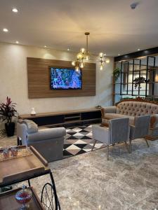 een lobby met een bank en een televisie aan de muur bij Arca's Hotel in Toledo