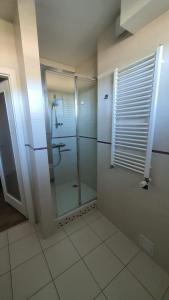 a bathroom with a shower with a glass door at Private Baltic Cliff Niechorze obok Latarni Morskiej in Niechorze