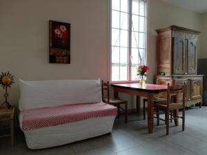 a living room with a table and a chair at LA MAISON D'ALIDA in Nueil-sous-Faye