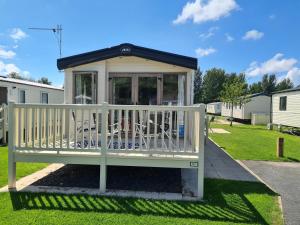 グレンジ・オーバー・サンズにあるThe Hideawayの庭の白いベンチ付きガゼボ +6枚の写真