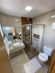 uma casa de banho com uma cabina de duche em vidro e um WC. em Arca's Hotel em Toledo