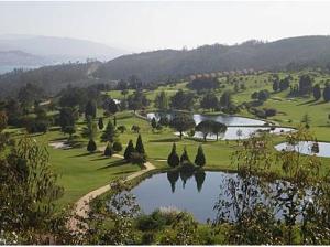 a view of a golf course with a pond at Casa Independiente Bella Vista in Moaña