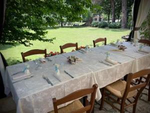 Tenuta Montelaura في Forino: طاولة طويلة مع قطعة قماش وكراسي بيضاء