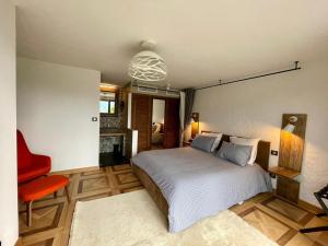 1 dormitorio con 1 cama y 1 silla roja en Escondida, en Niza