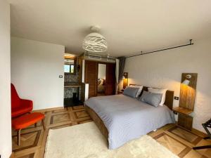 a bedroom with a bed and a red chair at Escondida in Nice