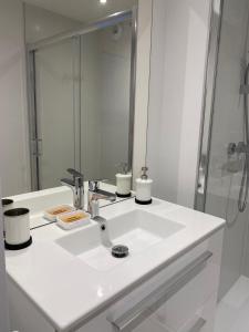 bagno bianco con lavandino e specchio di Les Remparts, cœur de ville La Rochelle a La Rochelle