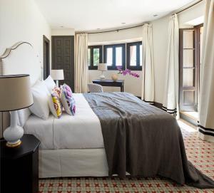 a bedroom with a large white bed with pillows at Soho Boutique Castillo de Santa Catalina - Adults Recommended in Málaga