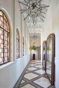 a hallway with a chandelier and a tiled floor at Soho Boutique Castillo de Santa Catalina - Adults Recommended in Málaga