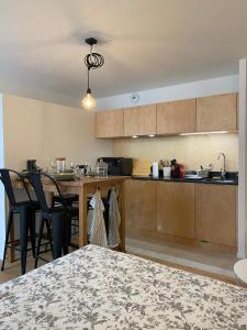 a kitchen with wooden cabinets and a table with chairs at Les Remparts, cœur de ville La Rochelle in La Rochelle