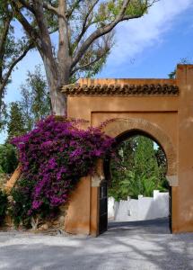 an arch with purple flowers on the side of a building at Soho Boutique Castillo de Santa Catalina - Adults Recommended in Málaga