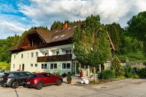 a house with two cars parked in front of it at Naturoase Appartements Mirnock in Afritz