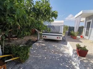 Green Garden Caravan في مدينة زاكينثوس: سيارة فان بيضاء متوقفة خارج المنزل