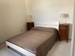 a small bedroom with a bed and a night stand at Porticciolo in Marina di Campo