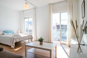 ein weißes Wohnzimmer mit einem Sofa und einem Tisch in der Unterkunft Apartamentos Casa Yoli en Maro in Maro