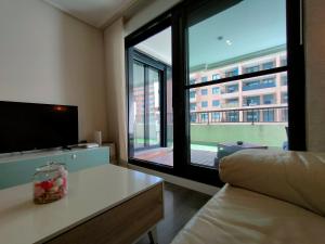a living room with a tv and a large window at NON STRESS First Level in Valencia