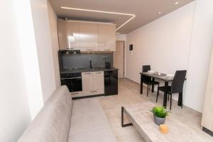 uma cozinha com um sofá e uma mesa num quarto em Kastalia Living Thessaloniki em Tessalônica