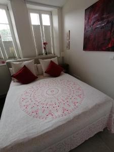 Un dormitorio con una gran cama blanca con almohadas rojas. en La Petite Trier, en Trier 9 fotos más