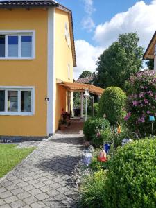 a yellow house with a garden in front of it at Ferienwohnung Rosemarie Wagner in Grafenau